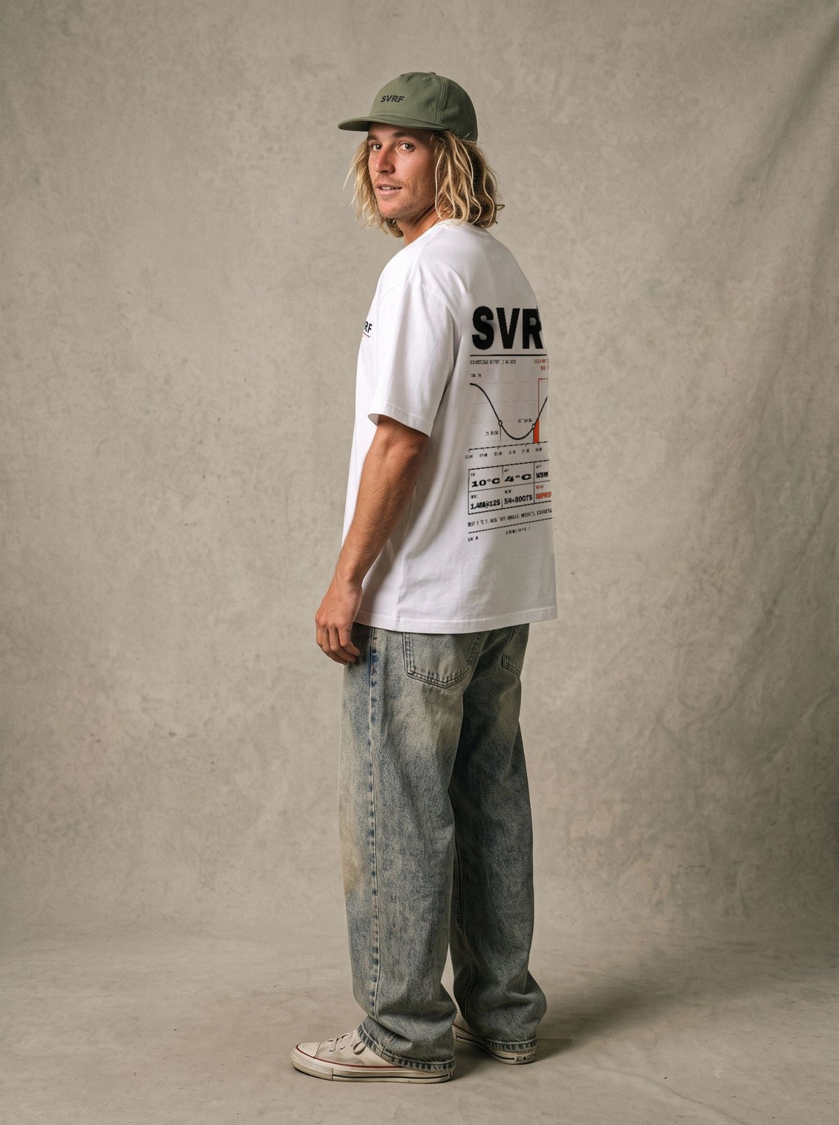 SVRF Forecast Tee in white, styled with a green cap and wide jeans, back three-quarter view