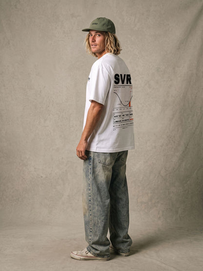 SVRF Forecast Tee in white, styled with a green cap and wide jeans, back three-quarter view